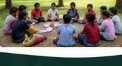 Children sitting in a circle on park grass