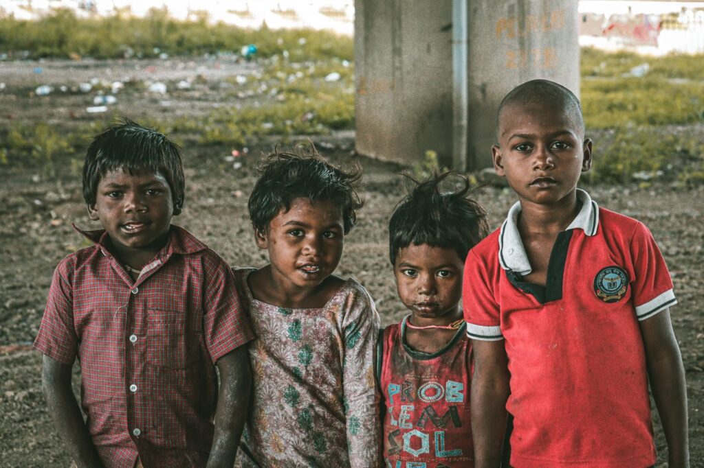 Group of four children posing under an urban bridge with expressions of resilience.